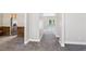 Hallway leading to a bright living space with plush carpet, fresh paint, and views into the kitchen at 5815 P.W.A. Dr, Cumming, GA 30041