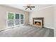 Bright living room featuring new carpet, a stone fireplace, white trim, and large windows with natural light at 5815 P.W.A. Dr, Cumming, GA 30041