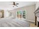 Bright living room featuring a ceiling fan, fireplace and windows offering serene backyard views at 5815 P.W.A. Dr, Cumming, GA 30041