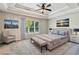 Luxurious bedroom featuring a trey ceiling, large window, sitting chair, and a bench at the foot of the bed at 5815 P.W.A. Dr, Cumming, GA 30041