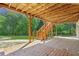 Covered patio with wooden deck above, stairs leading to yard and trees in background at 5815 P.W.A. Dr, Cumming, GA 30041