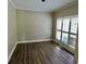 Room featuring wood floors, neutral walls, and a large window with bright light at 5815 P.W.A. Dr, Cumming, GA 30041