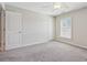 Bright bedroom featuring a ceiling fan, neutral walls, plush carpet, and a window providing natural light at 67 Narrowleaf Ln, Dallas, GA 30157