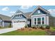 Charming home featuring light blue and gray siding, a two-car garage, and nicely landscaped front yard at 67 Narrowleaf Ln, Dallas, GA 30157
