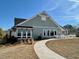 A light-green modern community building with large windows and outdoor seating, complemented by landscaped grounds and clear skies at 67 Narrowleaf Ln, Dallas, GA 30157