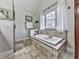 Bathroom featuring a soaking tub with tile surround, framed window, and a glass shower stall at 750 Maggie Nw Ct, Kennesaw, GA 30144