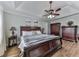 Relaxing main bedroom featuring a tray ceiling, hardwood floors, and dark wood furnishings at 750 Maggie Nw Ct, Kennesaw, GA 30144