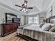Comfortable main bedroom with tray ceiling, fan, hardwood floors, and large dresser with mounted TV at 750 Maggie Nw Ct, Kennesaw, GA 30144
