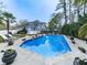 Expansive pool area with lush landscaping, comfortable lounge chairs, and umbrellas, ideal for outdoor entertaining at 750 Maggie Nw Ct, Kennesaw, GA 30144