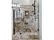 Custom tiled walk-in shower with a glass enclosure, built-in shelving, and a rainfall showerhead at 750 Maggie Nw Ct, Kennesaw, GA 30144
