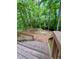 Landscaped backyard with wooded surroundings and an American flag view from deck stairs at 802 Eagle Glen Xing, Woodstock, GA 30189