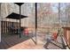 Outdoor deck with seating and umbrella overlooking the wooded yard at 802 Eagle Glen Xing, Woodstock, GA 30189