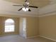 Bright bedroom featuring a ceiling fan, tray ceiling, and a large arched window at 1211 Saxony Se Dr, Conyers, GA 30013