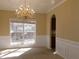 Traditional dining room featuring a dazzling chandelier, wainscoting, and a large window at 1211 Saxony Se Dr, Conyers, GA 30013