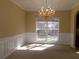 Bright and airy dining room with large windows, wainscoting, and elegant chandelier at 1211 Saxony Se Dr, Conyers, GA 30013