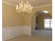 This dining room boasts an elegant chandelier, wainscoting, and an archway entrance at 1211 Saxony Se Dr, Conyers, GA 30013