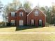 Charming two-story brick home with a well-manicured lawn and classic architectural details at 1211 Saxony Se Dr, Conyers, GA 30013