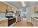 Modern kitchen features stainless steel appliances and hardwood floors, with an open layout to the living space at 16 Montclair Ct, Cartersville, GA 30121
