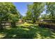 A level backyard is surrounded by a wood fence, tall trees, and green foliage at 2628 White Oak Dr, Decatur, GA 30032