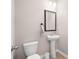 Cozy powder room features a pedestal sink, decorative mirror, and modern fixtures at 353 Franklin Ln, Acworth, GA 30102