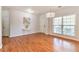Airy living room featuring hardwood floors, a modern chandelier, and ample natural light from a large window at 3455 Flycatcher Way, Duluth, GA 30097