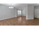 Spacious living room featuring hardwood floors and elegant chandeliers that amplify the bright, open space at 3455 Flycatcher Way, Duluth, GA 30097