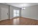 Bright living room with hardwood floors, a large window, and a stylish chandelier that enhances the space at 3455 Flycatcher Way, Duluth, GA 30097