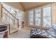 Warm entryway with stairs, large windows, and a comfortable chaise lounge at 3828 Morning Meadow Ln, Buford, GA 30519