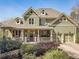 Charming two-story home with a welcoming front porch, lush landscaping, and an attached two-car garage at 3828 Morning Meadow Ln, Buford, GA 30519