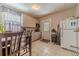 Eat in kitchen area with wooden table and neutral tone cabinets, complete with a window view at 3828 Morning Meadow Ln, Buford, GA 30519