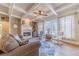 Cozy living room featuring a fireplace, coffered ceiling, large windows, and comfortable seating at 3828 Morning Meadow Ln, Buford, GA 30519