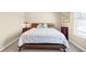 A cozy bedroom with a wooden bed frame and a window letting in natural light at 5034 Little Harbor Way, Acworth, GA 30101