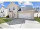 Beige two-story home with a two-car garage, well-kept lawn, and a concrete driveway at 5034 Little Harbor Way, Acworth, GA 30101