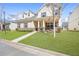 Two-story home features a well-kept lawn, stone accents, and a quaint covered front porch at 5034 Little Harbor Way, Acworth, GA 30101
