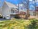 Spacious backyard with a deck, lush lawn, mature trees, and convenient garage access at 6009 Wyndham Woods Dr, Powder Springs, GA 30127