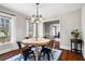 Charming dining room with a stylish chandelier, hardwood floors, and sunlit windows at 6009 Wyndham Woods Dr, Powder Springs, GA 30127