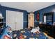 Comfortable bedroom with navy blue walls, a closet, and a colorful bed with fun character-themed bedding at 5136 Heron Bay Blvd, Locust Grove, GA 30248