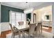 Elegant dining room boasts a modern chandelier, wainscoting, and an open floor plan to the entry way and adjoining rooms at 5136 Heron Bay Blvd, Locust Grove, GA 30248
