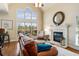 Bright living room showcases a large window, fireplace with stone surround, and hardwood flooring at 5136 Heron Bay Blvd, Locust Grove, GA 30248