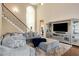 Spacious living room with plush seating, elegant staircase, and modern entertainment center at 5136 Heron Bay Blvd, Locust Grove, GA 30248