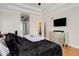 Bright bedroom featuring a tray ceiling, modern dresser, mounted television and ensuite bathroom at 5136 Heron Bay Blvd, Locust Grove, GA 30248