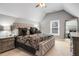 Spacious main bedroom with a vaulted ceiling, large bed with padded headboard, and a sitting area by the window at 5136 Heron Bay Blvd, Locust Grove, GA 30248