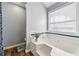 Bathroom with tiled bathtub, chrome fixtures, and natural light from the window at 880 Hillary Ln, Lawrenceville, GA 30043