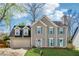Two-story home featuring light gray siding, dormer windows, attached garage, manicured lawn, and shutters at 880 Hillary Ln, Lawrenceville, GA 30043