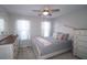This is a quaint bedroom featuring neutral paint, carpet flooring, windows for natural light, and a ceiling fan at 895 Burton Ridge Dr, Loganville, GA 30052