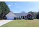 Charming single Gathering home featuring a large front yard, attached garage, and beautiful landscaping at 895 Burton Ridge Dr, Loganville, GA 30052