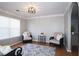 Cozy living room with hardwood floors, gray rug, natural light and stylish lighting fixture at 895 Burton Ridge Dr, Loganville, GA 30052