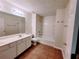 Bright bathroom features a double sink vanity, a shower-tub combo, and tile flooring at 523 Lantern Wood Dr, Scottdale, GA 30079