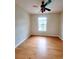 Bedroom featuring hardwood floors, a ceiling fan, and a bright window with outside views at 523 Lantern Wood Dr, Scottdale, GA 30079