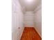 A walk-in closet features wood flooring and white shelving units for ample storage at 523 Lantern Wood Dr, Scottdale, GA 30079